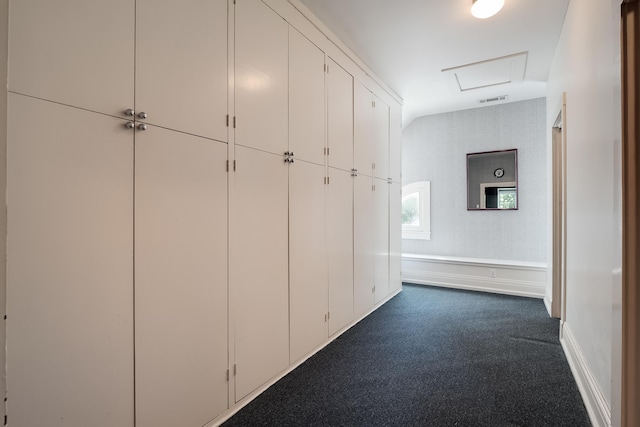 hall featuring dark colored carpet