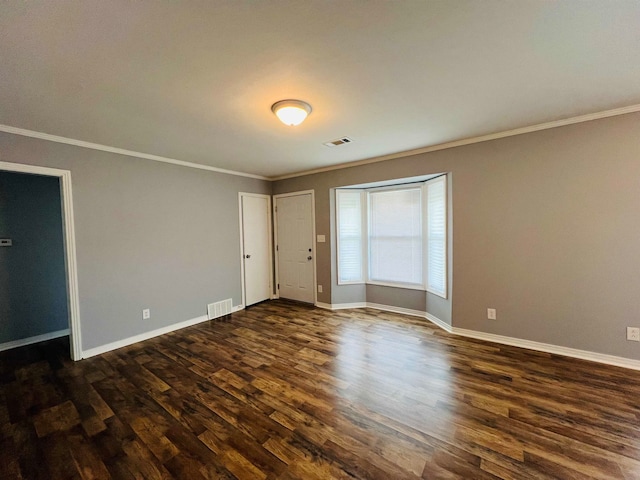 unfurnished room featuring ornamental molding and dark wood-type flooring