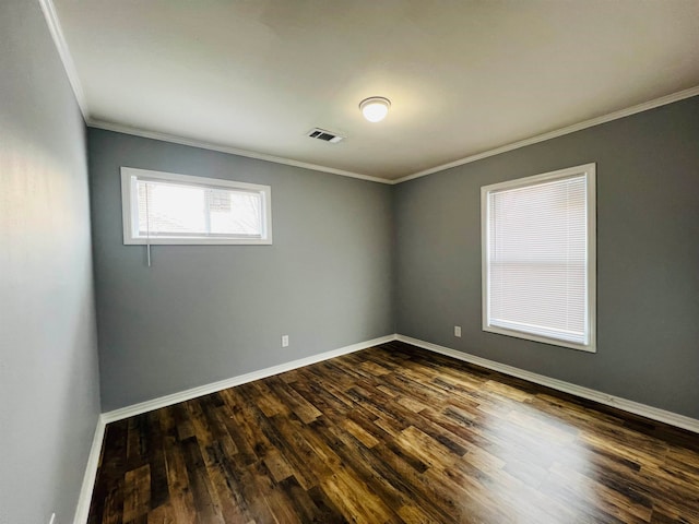 spare room featuring ornamental molding and dark hardwood / wood-style floors