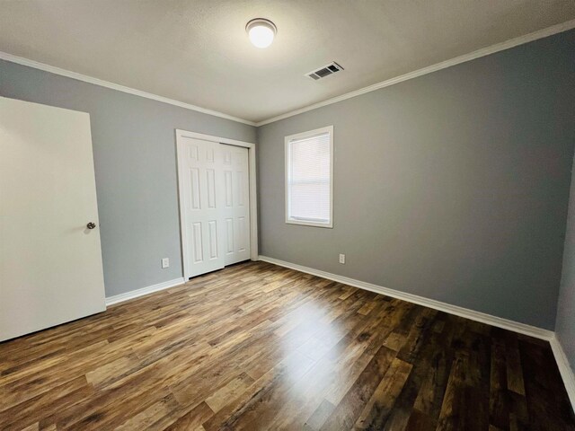 empty room featuring crown molding and hardwood / wood-style flooring