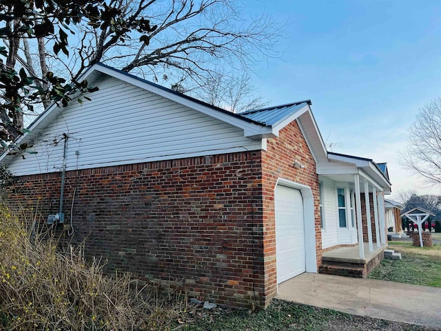 view of side of home with a porch and a garage