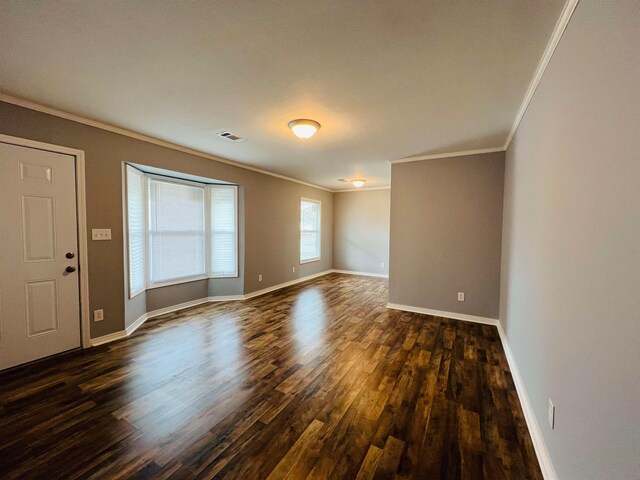 spare room featuring dark hardwood / wood-style flooring and ornamental molding