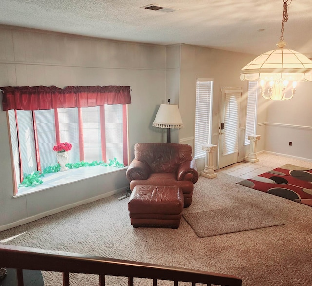 living room featuring a chandelier, light carpet, a textured ceiling, and a wealth of natural light