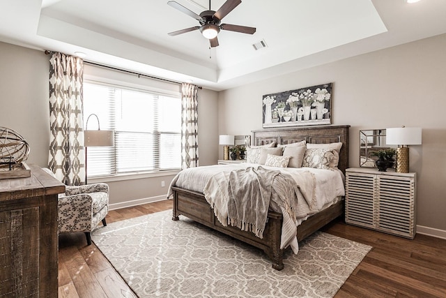 bedroom with a tray ceiling, ceiling fan, and hardwood / wood-style floors