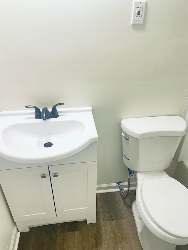 bathroom featuring toilet, hardwood / wood-style floors, and vanity