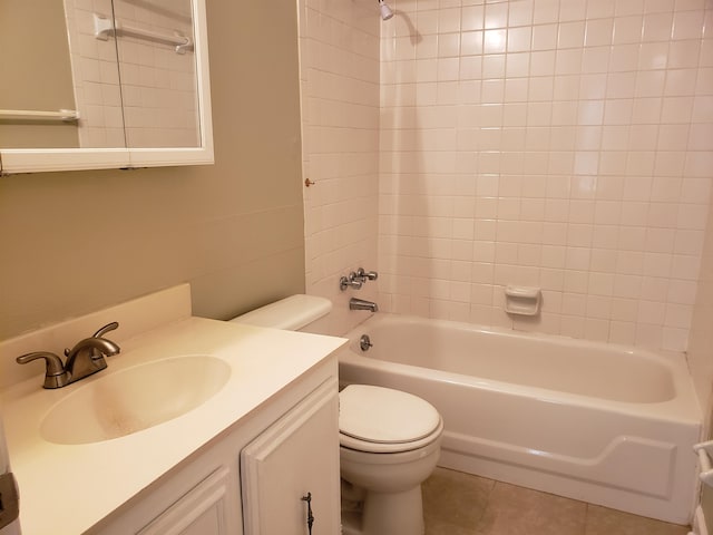 full bathroom with tiled shower / bath, toilet, tile floors, and vanity