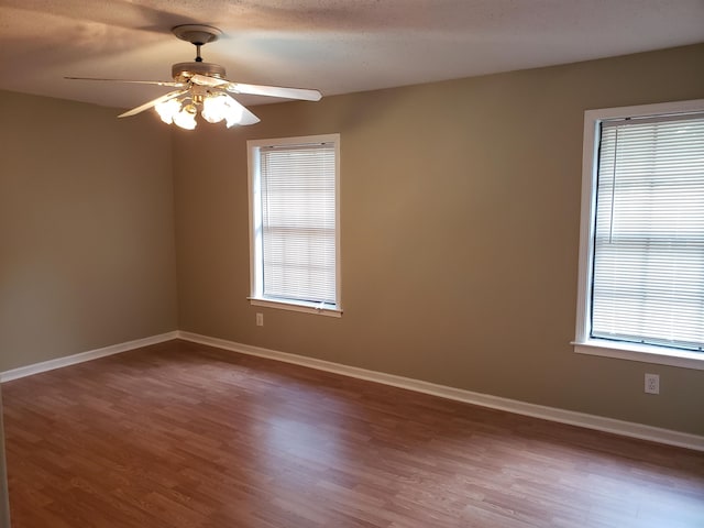 spare room with dark hardwood / wood-style floors and ceiling fan