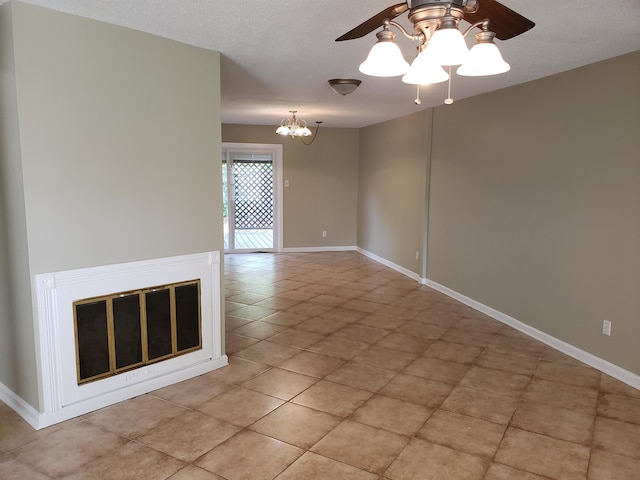 unfurnished living room featuring light tile flooring, a textured ceiling, and ceiling fan with notable chandelier