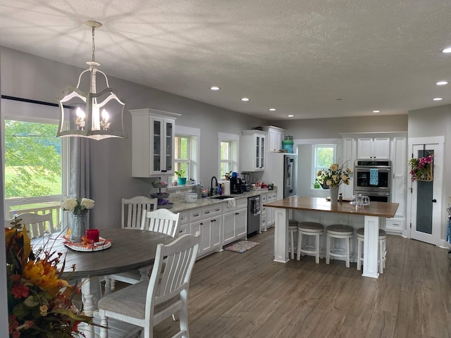 dining space featuring a chandelier, a textured ceiling, dark hardwood / wood-style floors, and sink