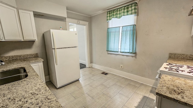 kitchen with sink, white cabinets, a healthy amount of sunlight, and white refrigerator