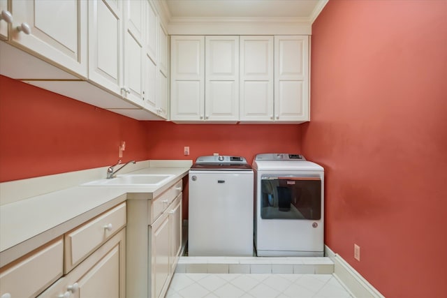 laundry room featuring light tile floors, separate washer and dryer, cabinets, crown molding, and sink