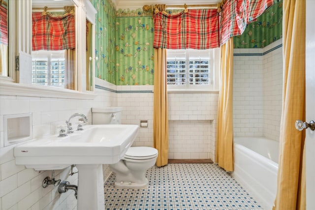 bathroom with tile walls, toilet, tile floors, and shower / tub combo with curtain