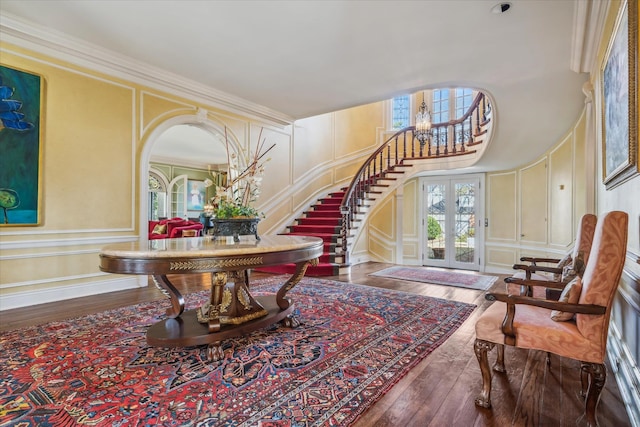 interior space featuring a notable chandelier, ornamental molding, dark hardwood / wood-style floors, and french doors