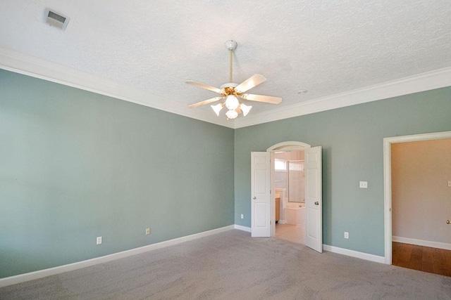 unfurnished bedroom featuring light colored carpet, a textured ceiling, ceiling fan, and crown molding