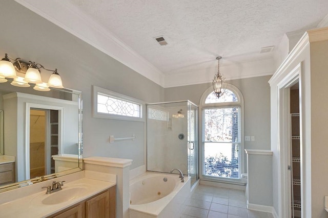 bathroom with a textured ceiling, a wealth of natural light, and vanity