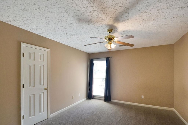 carpeted spare room featuring ceiling fan and a textured ceiling