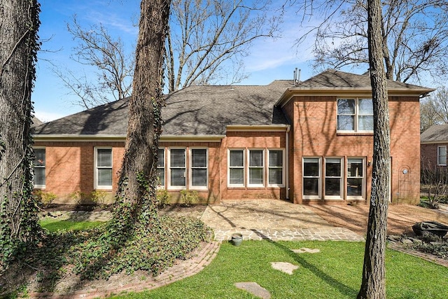 back of property with a lawn and a patio