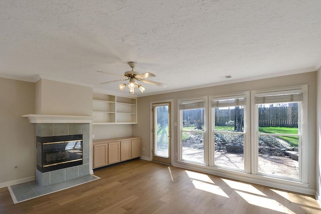 unfurnished living room featuring light hardwood / wood-style flooring, ceiling fan, and a fireplace