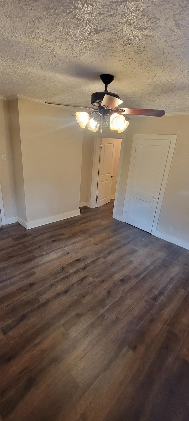 unfurnished bedroom with ceiling fan, a textured ceiling, and dark wood-type flooring