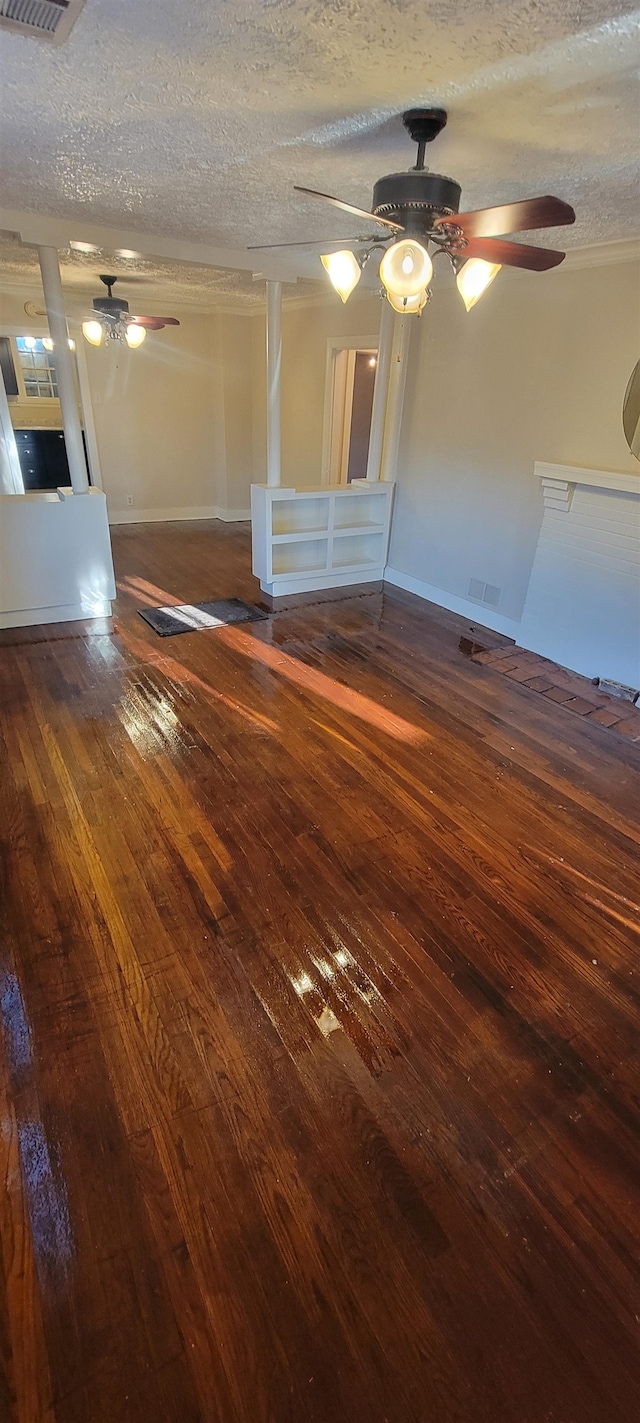 empty room featuring a textured ceiling, ceiling fan, and dark wood-type flooring