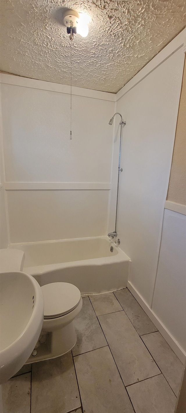 full bathroom with toilet, a textured ceiling, shower / tub combination, tile floors, and sink