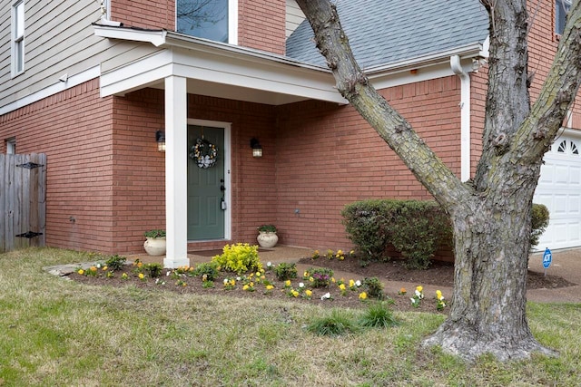 entrance to property featuring a yard, a garage, and a porch