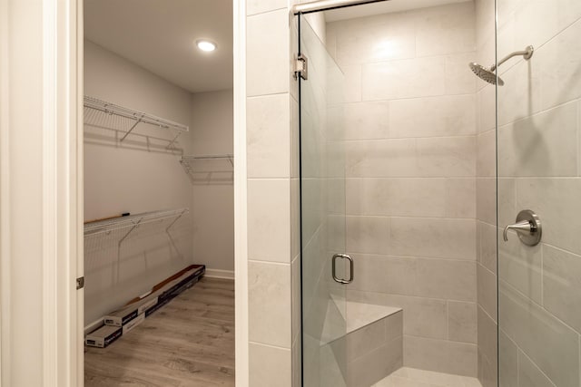 bathroom featuring hardwood / wood-style flooring and a shower with shower door