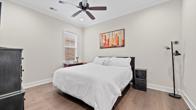 bedroom featuring ornamental molding, ceiling fan, and dark wood-type flooring