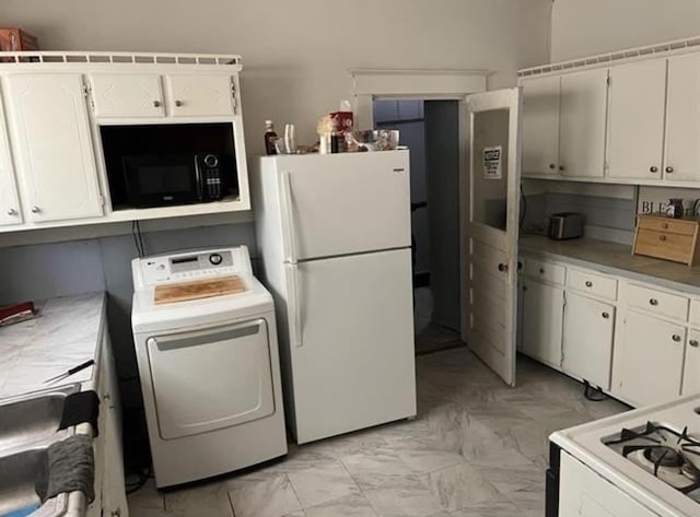 kitchen with light tile floors, white cabinets, washer / dryer, and white fridge