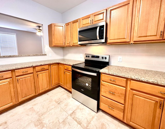 kitchen with stainless steel appliances, light tile floors, light stone countertops, ceiling fan, and tasteful backsplash