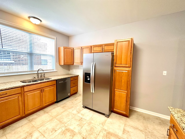 kitchen featuring light tile flooring, light stone countertops, stainless steel appliances, and sink