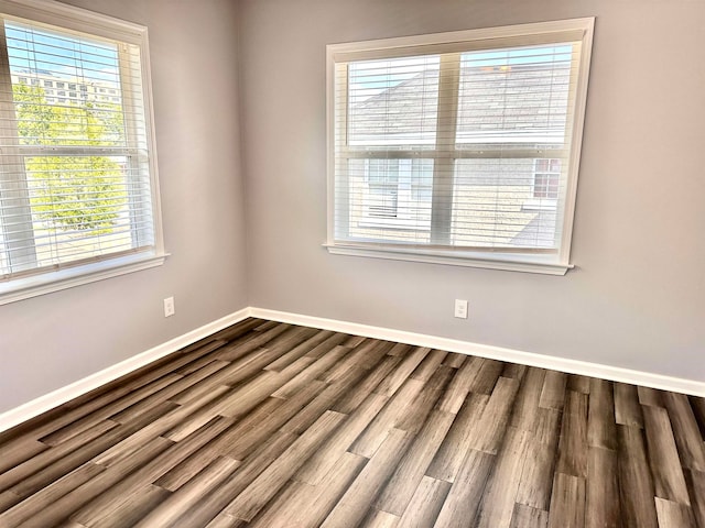 unfurnished room with dark hardwood / wood-style flooring