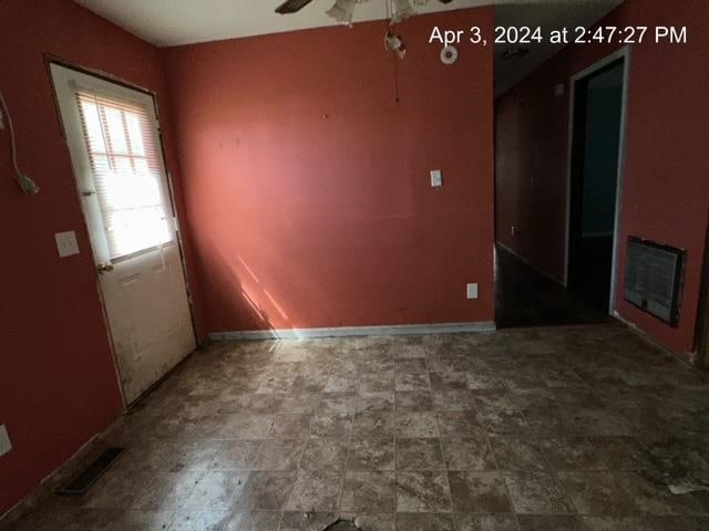 tiled empty room featuring ceiling fan