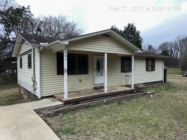 view of front of house with a front yard and a porch