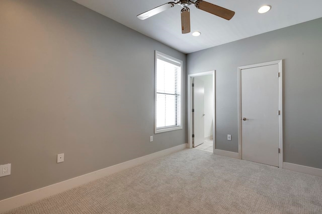 unfurnished bedroom with light colored carpet and ceiling fan