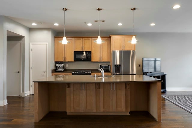 kitchen with dark wood-type flooring, an island with sink, stainless steel fridge, decorative light fixtures, and stove