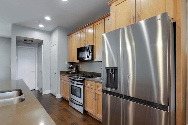 kitchen featuring stainless steel appliances, sink, light brown cabinets, and dark hardwood / wood-style floors