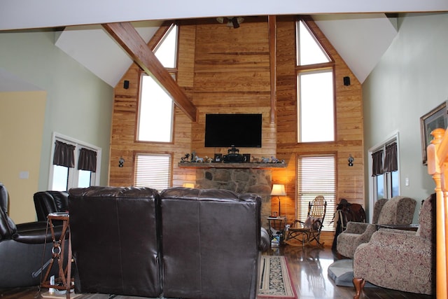 living room featuring beamed ceiling, a fireplace, wood walls, high vaulted ceiling, and hardwood / wood-style flooring