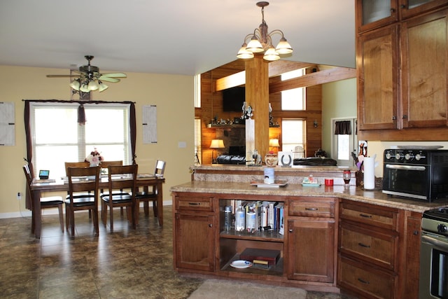 kitchen with pendant lighting, dark tile floors, light stone counters, and ceiling fan with notable chandelier