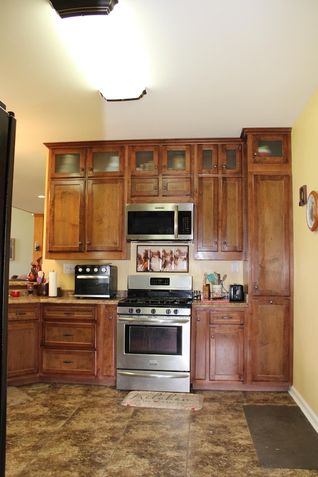 kitchen featuring appliances with stainless steel finishes and dark tile flooring