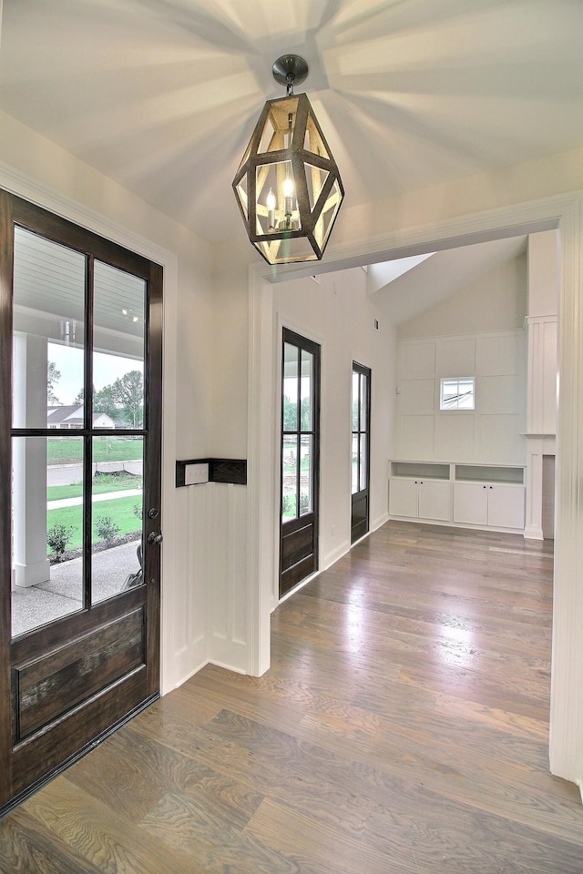 entryway featuring a notable chandelier, lofted ceiling, and hardwood / wood-style floors