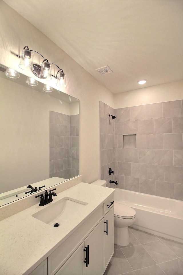 full bathroom with toilet, tile patterned floors, tiled shower / bath combo, and vanity