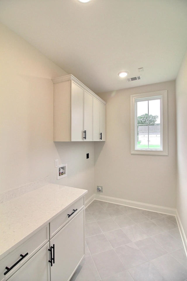 washroom featuring hookup for an electric dryer, washer hookup, cabinets, and light tile patterned floors