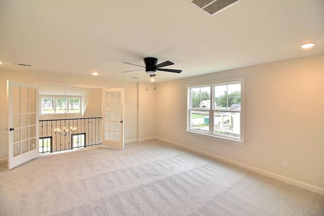 carpeted spare room with ceiling fan and french doors