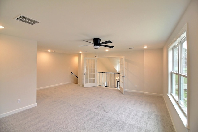 empty room featuring ceiling fan and light colored carpet