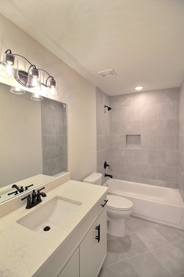 full bathroom with vanity, tiled shower / bath, tile patterned flooring, and toilet