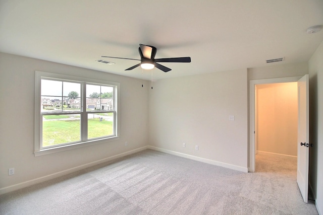 carpeted spare room featuring ceiling fan