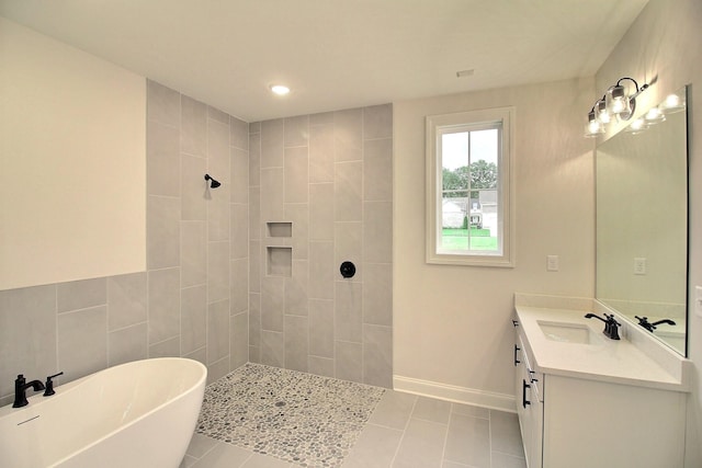 bathroom featuring tile patterned floors, vanity, and a tile shower