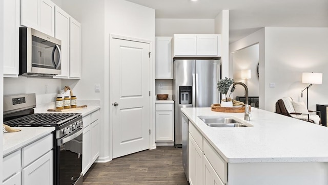 kitchen featuring sink, white cabinetry, dark hardwood / wood-style flooring, stainless steel appliances, and a center island with sink