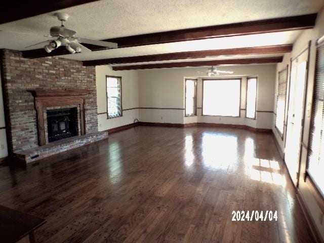 unfurnished living room with hardwood / wood-style floors, ceiling fan, a fireplace, and a textured ceiling